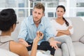 Unhappy couple at therapy session with man talking to therapist Royalty Free Stock Photo