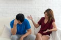 Unhappy couples home. Handsome man and beautiful young woman having quarrel. Sitting on white sofa together. Couple having