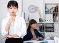 Frustrated asian woman standing at office