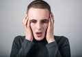 Unhappy crying man with dropping tears on the face with headache holding the head. Closeup studio portrait on grey background. Royalty Free Stock Photo