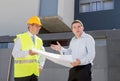 Unhappy customer in stress and constructor foreman worker arguing outdoors on new house building blueprints Royalty Free Stock Photo