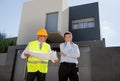 Unhappy customer in stress and constructor foreman worker with helmet and vest arguing outdoors on new house building blueprints Royalty Free Stock Photo