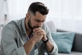 Unhappy depressed caucasian handsome bearded man crying in living room couch, feeling desperate Royalty Free Stock Photo