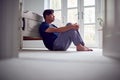 Unhappy And Depressed Mature Asian Man In Pyjamas Sitting On Bedroom Floor Royalty Free Stock Photo