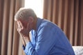 Unhappy And Depressed Senior Man With Head In Hands Sitting On Edge Of Bed At Home Royalty Free Stock Photo