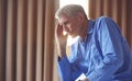 Unhappy And Depressed Senior Man With Head In Hands Sitting On Edge Of Bed At Home Royalty Free Stock Photo