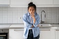 Unhappy disheveled Asian girl drinks water while standing in kitchen waking up late morning bad mood Royalty Free Stock Photo