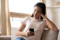 Unhappy dissatisfied Asian woman looking at smartphone screen