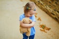 Unhappy and emotional toddler girl sitting on the floor outdoors