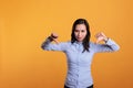 Unhappy filipino woman showing dislike gesture on camera