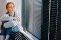 unhappy frustrated female doctor crying sitting near window in sunny day.