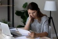 Unhappy frustrated woman reading unexpected bad news in letter