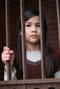 Unhappy girl standing behind bars Royalty Free Stock Photo