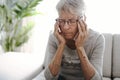 Unhappy headache Retired Senior Woman Sitting On Sofa At Home Royalty Free Stock Photo