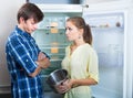 Unhappy hungry couple near empty fridge Royalty Free Stock Photo