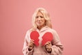 Unhappy lady holding two halves of cut paper heart and crying, feeling hurt, going through romantic relationship breakup