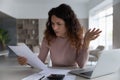 Unhappy Latin woman distressed with news in letter