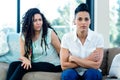 Unhappy lesbian couple sitting on sofa