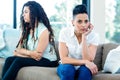 Unhappy lesbian couple sitting on sofa