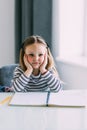 Unhappy little Caucasian girl child sit at table at home feel lazy unmotivated doing homework assignment. Upset distressed small Royalty Free Stock Photo