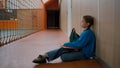 Unhappy little girl sitting floor gym tired primary school lesson schoolgirl fatigue weary child alone frustrated inside Royalty Free Stock Photo