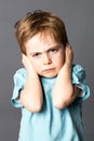 Unhappy little kid disliking his education, protecting his closed ears Royalty Free Stock Photo