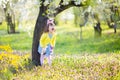 Unhappy little sad and angry crying bunny girl holding rabbit toy in the spring blossom garden