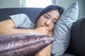 Unhappy lonely depressed woman at home. she is lying on the couch and hiding her face on a pillow, depression concept Royalty Free Stock Photo