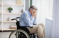 Unhappy and lonely senior handicapped man in wheelchair crying at home Royalty Free Stock Photo