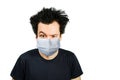 Unhappy, mad person wearing a protective face mask prevent virus infection or pollution on white isolated background Royalty Free Stock Photo