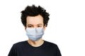 Unhappy, mad young man wearing a protective face mask prevent virus infection or pollution on white isolated background Royalty Free Stock Photo