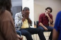 Unhappy Man Attending Self Help Therapy Group Meeting In Community Center