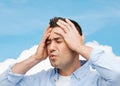 Unhappy man with closed eyes touching his forehead Royalty Free Stock Photo