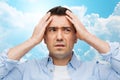 Unhappy man with closed eyes touching his forehead Royalty Free Stock Photo