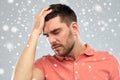 Unhappy man suffering from head ache over snow Royalty Free Stock Photo