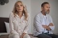 Unhappy mature couple sitting apart in silence