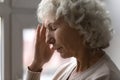 Unhappy elderly woman yearning alone at home