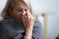 Unhappy mature woman covered blanket feeling bad, sneezing