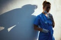 Unhappy modern physician woman outdoors in city near wall