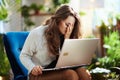 Unhappy modern woman at modern home in sunny day using laptop