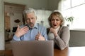 Unhappy old couple shocked by bad news on laptop Royalty Free Stock Photo