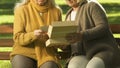 Unhappy old women watching photo together, remembering relatives, bereavement