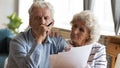 Unhappy older couple reading documents, checking domestic bills