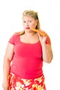 Unhappy overweight blond woman with raw carrot