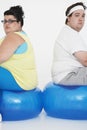 Unhappy Overweight Couple Sitting On Exercise Balls Royalty Free Stock Photo