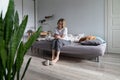 Unhappy pessimistic woman sits on bed with phone in hands waiting for call from boyfriend or husband Royalty Free Stock Photo