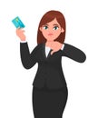 Unhappy, professional business woman showing/holding credit/debit/ATM banking card and gesturing/making thumbs down sign. Bad. Royalty Free Stock Photo