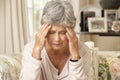 Unhappy Retired Senior Woman Sitting On Sofa At Home