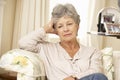 Unhappy Retired Senior Woman Sitting On Sofa At Home Royalty Free Stock Photo