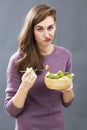 Unhappy 20s girl questioning the taste of a mixed green salad Royalty Free Stock Photo